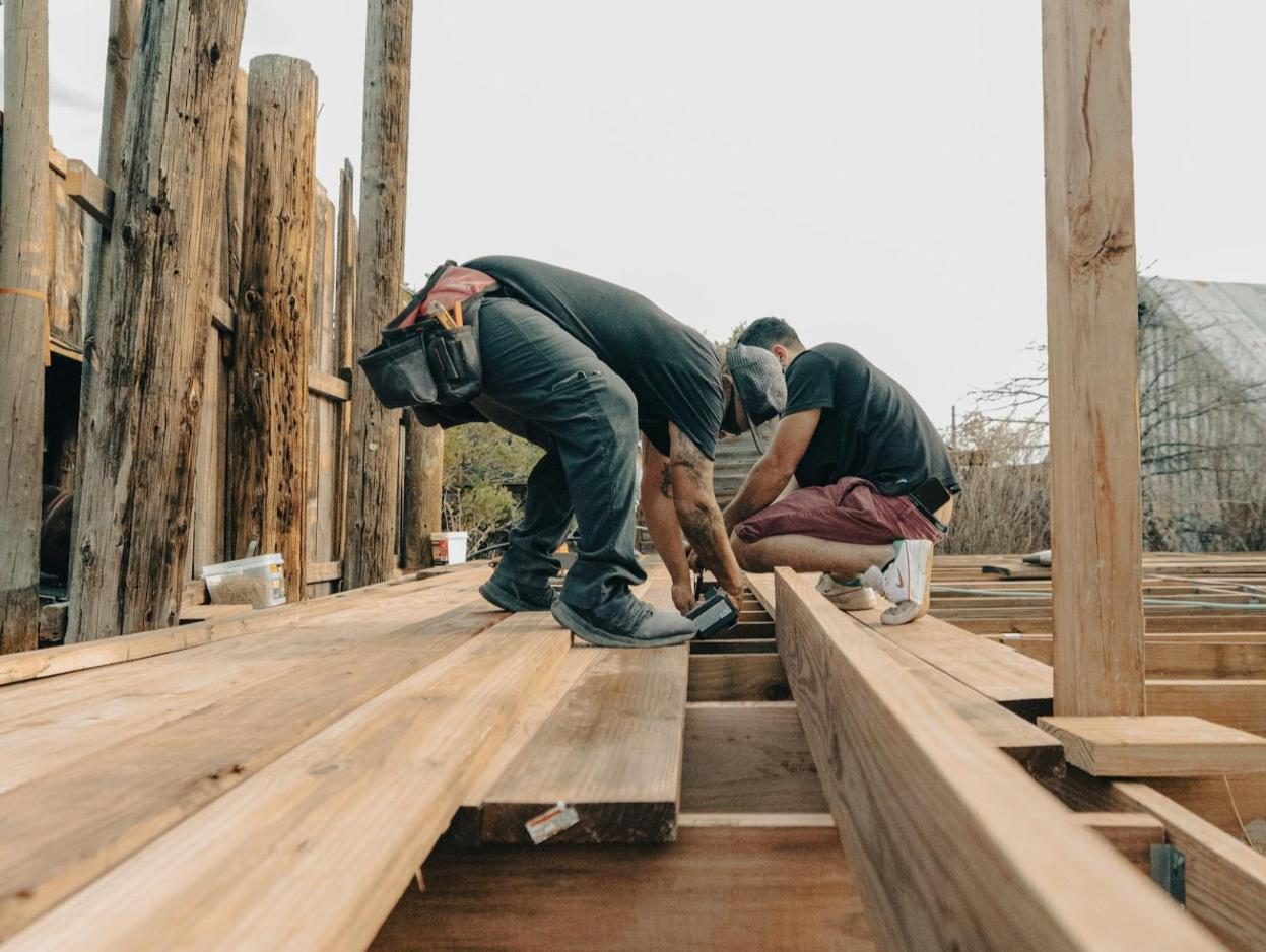 Crew fastening deck framing between timber posts