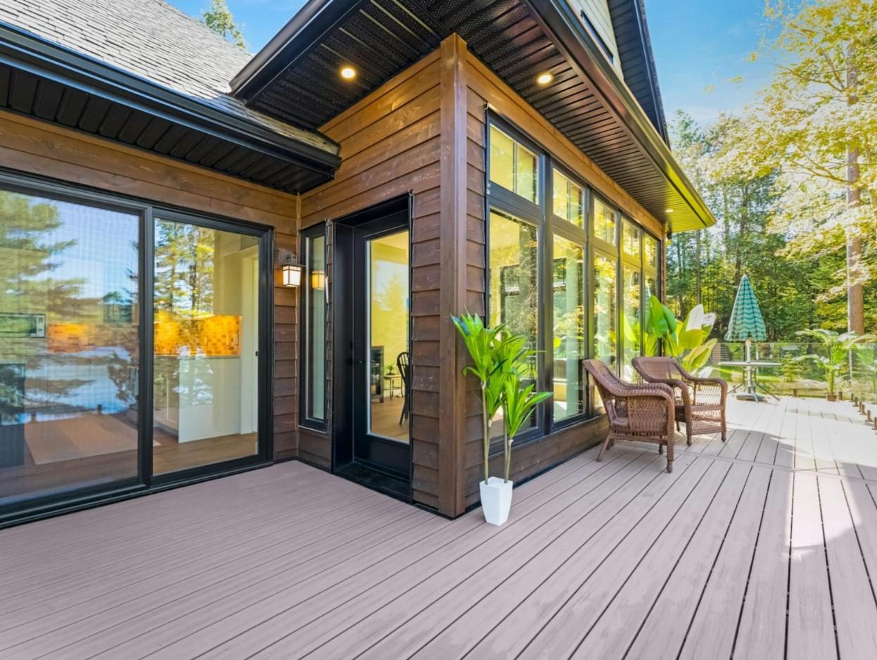 Composite deck outside a modern house with wide glass doors