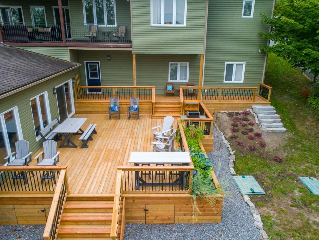 Aerial view of a terraced cedar deck with stairs, dining tables and planters