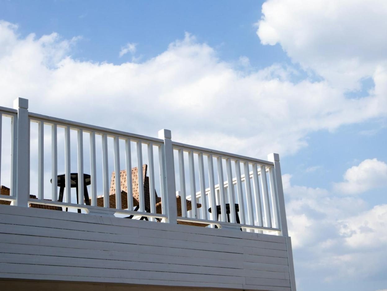 Upper deck with a white railing against a blue sky